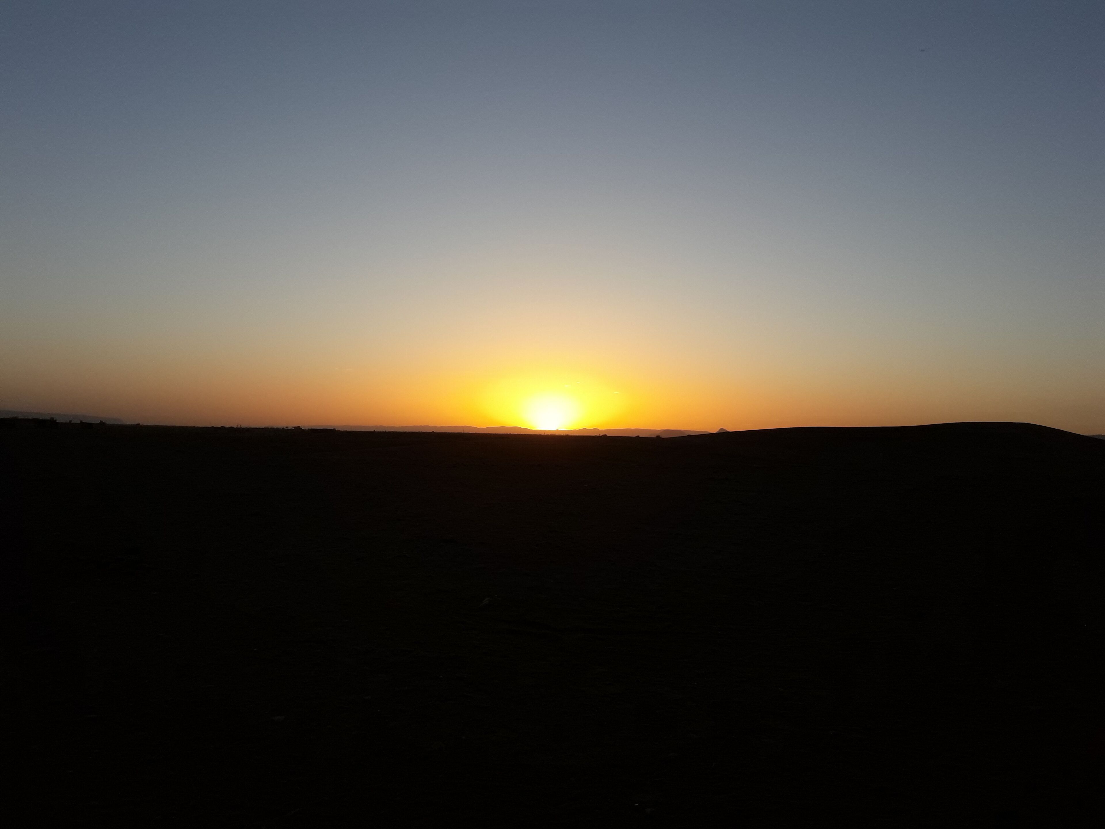Un atardecer sobre un paisaje llano, sin estructuras ni elementos visibles.