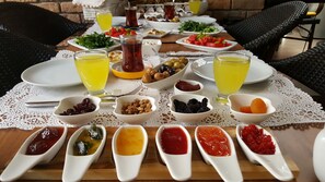 A table set with various dishes, including olives, tomatoes, and bowls of different foods, suggesting a meal setting.