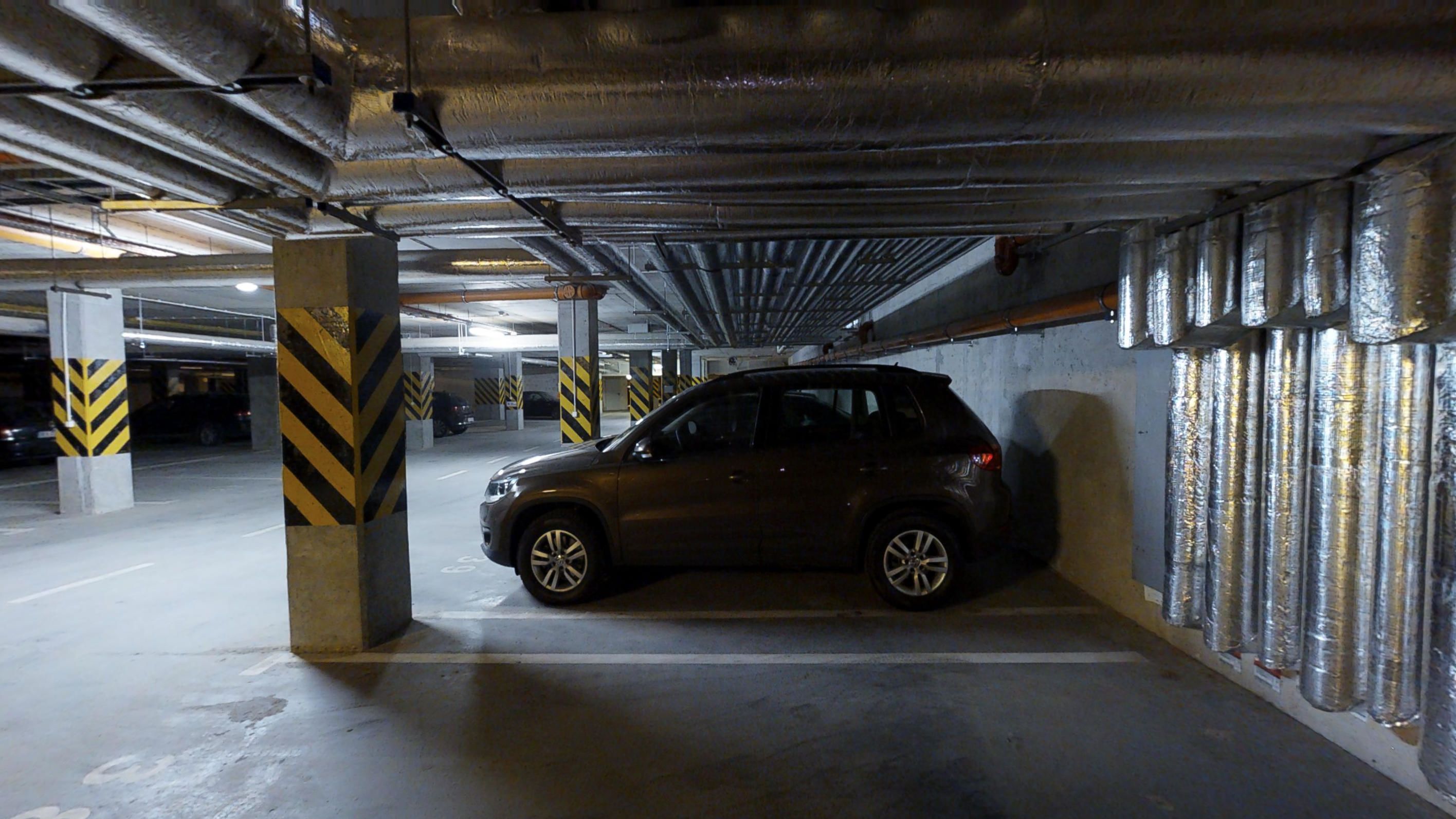 Un parking où une voiture est garée dans une place.