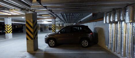 Uma garagem de estacionamento com um carro estacionado em uma vaga.