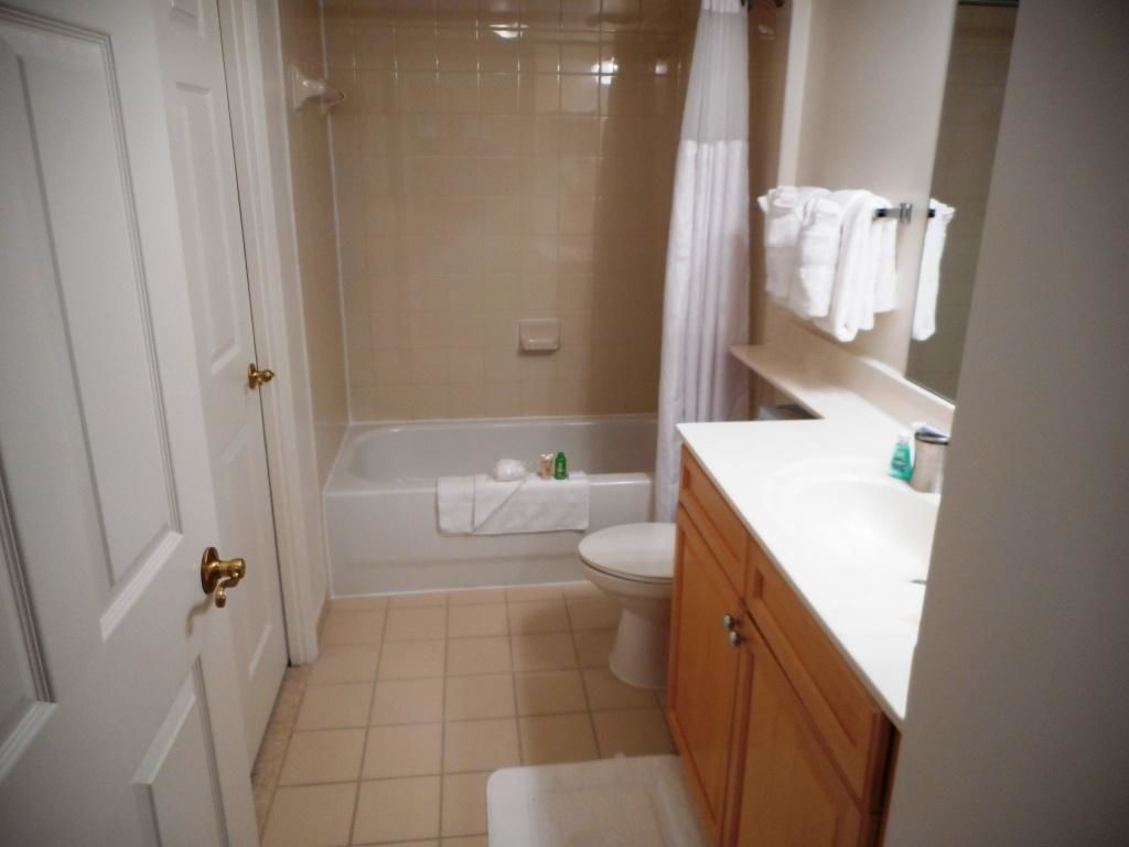 A bathroom with a bathtub, toilet, and vanity.