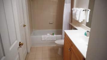 A bathroom with a bathtub, toilet, and vanity.