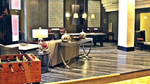 A hotel lobby with a foosball table, a bar area, and a seating area with a sofa and chairs. - Weichert Suites at Thomas Circle (Washington)