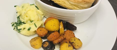 A plate with a pastry, mashed potatoes, and roasted potatoes.