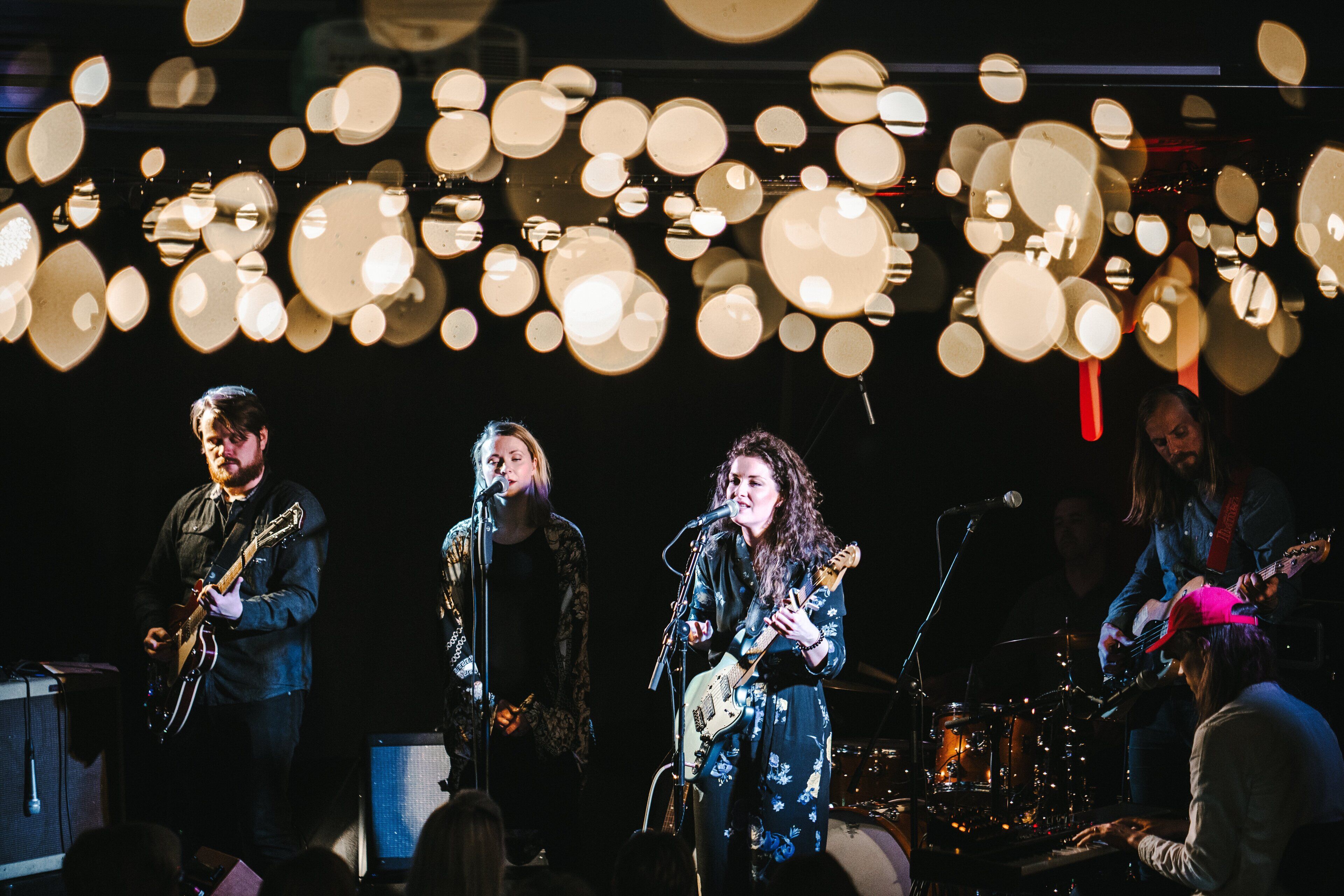 A band performing on stage with musical instruments and microphones.
