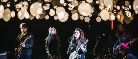 A band performing on stage with musical instruments and microphones.