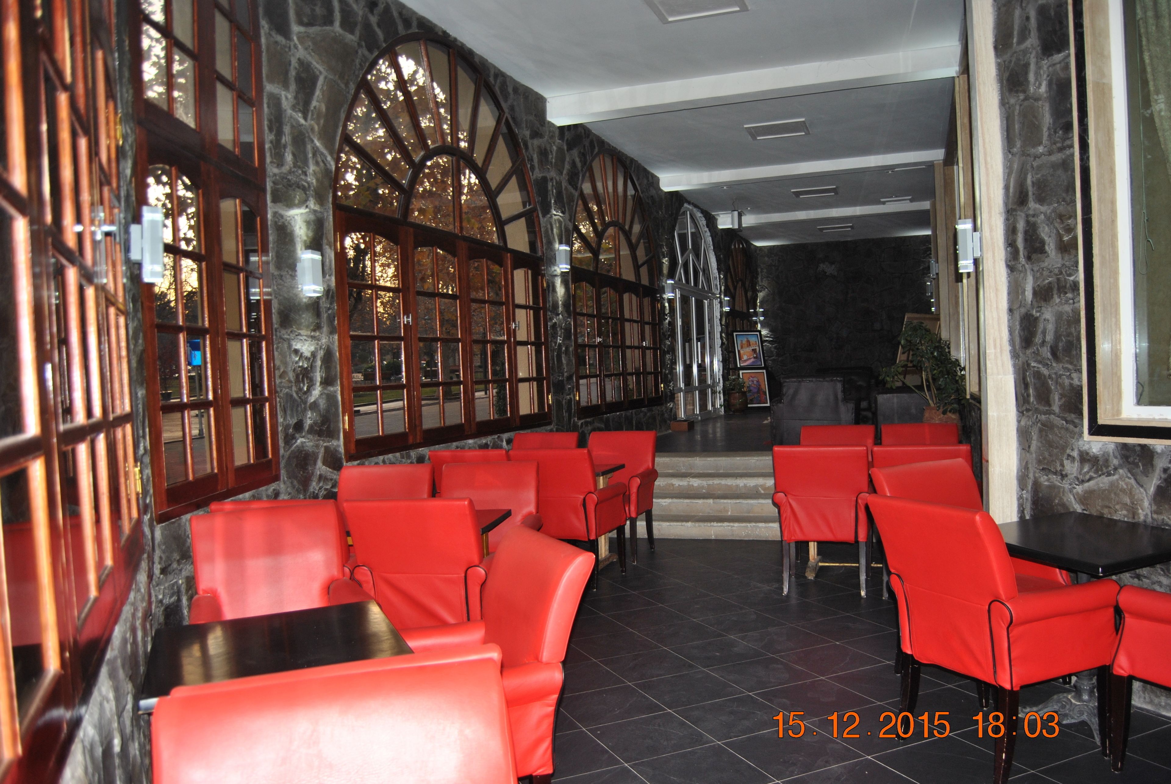 A restaurant with red seating and stone walls.