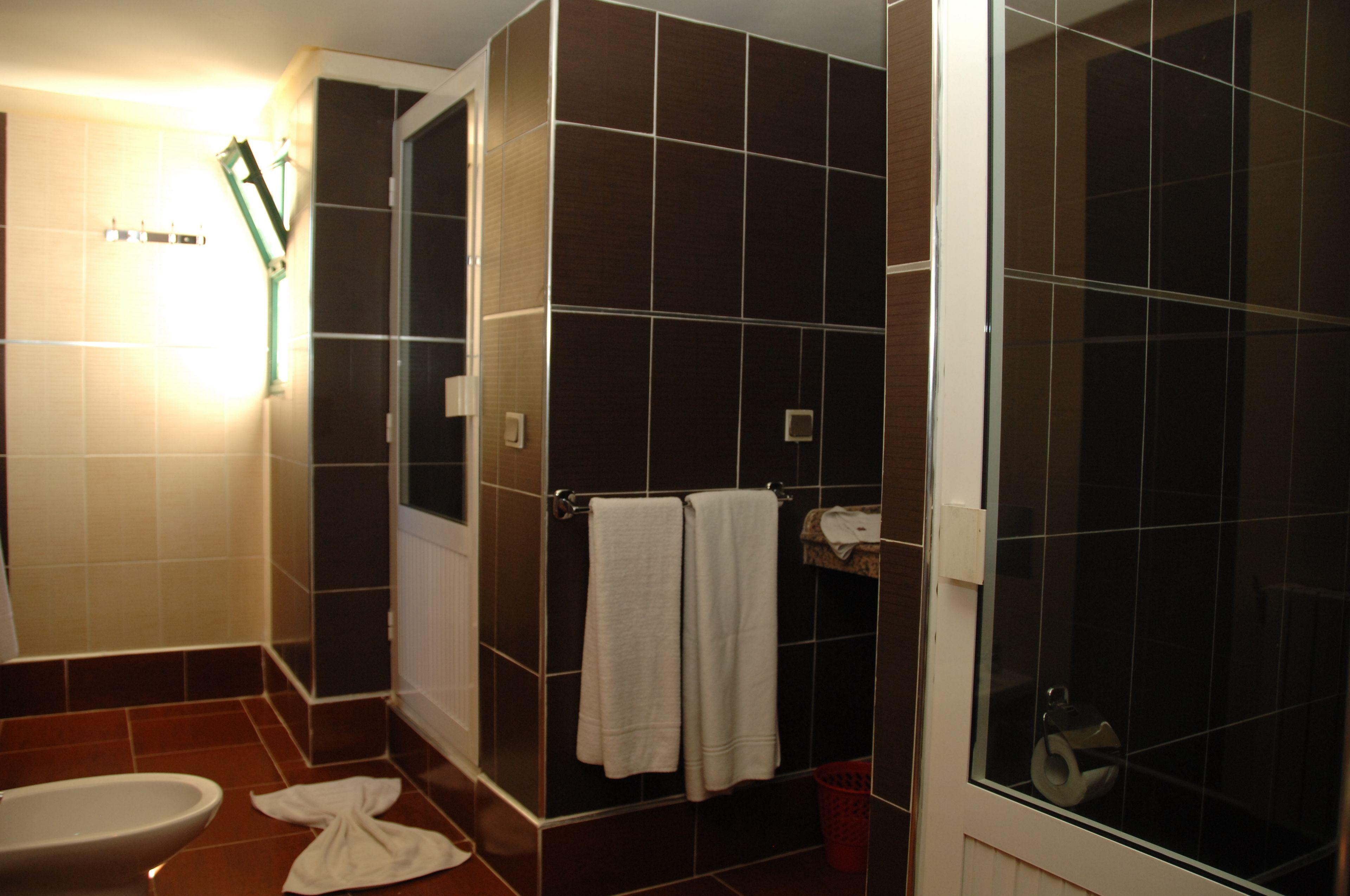 A bathroom with a toilet, a shower, and a sink.