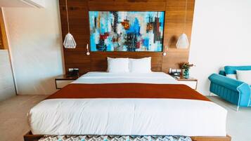 Ein modernes Hotelzimmer mit einem großen Bett, einem Stadtbild an der Wand und einem blauen Sofa.