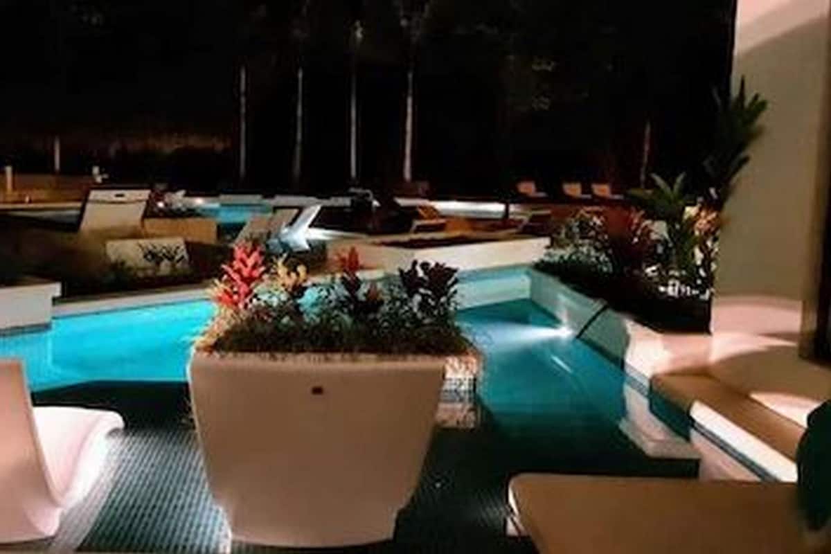 A poolside area with lounge chairs and potted plants.