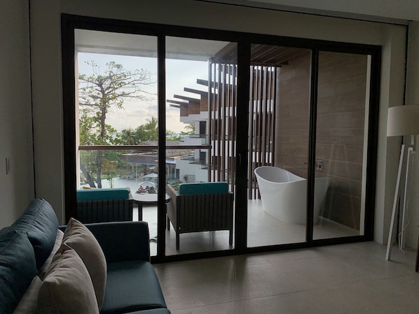A modern living room with a sliding glass door leading to a balcony. - Azura Beach Resort - All Inclusive - Adults Only (Sámara)