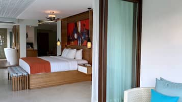 Una habitación de hotel moderna con una cama grande, una mesita de noche y vistas a través de un ventanal corredero.