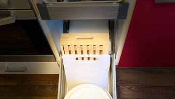 A drawer with a white circular object, a wooden handle, and a metal frame.