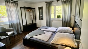 A modern bedroom with a bed, a desk, and a chair.