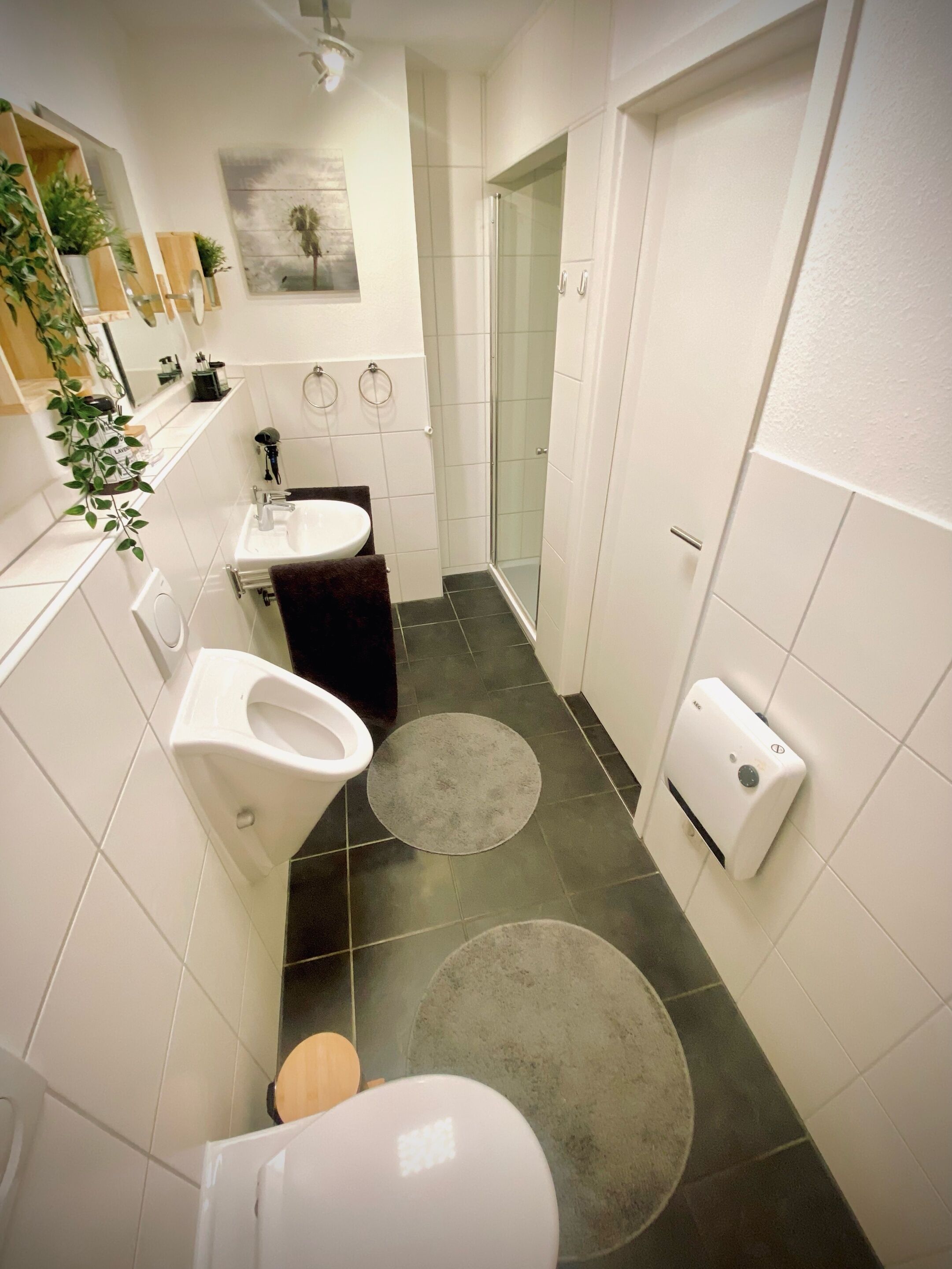 Ein kleines Badezimmer mit Toilette, Waschbecken und Dusche.