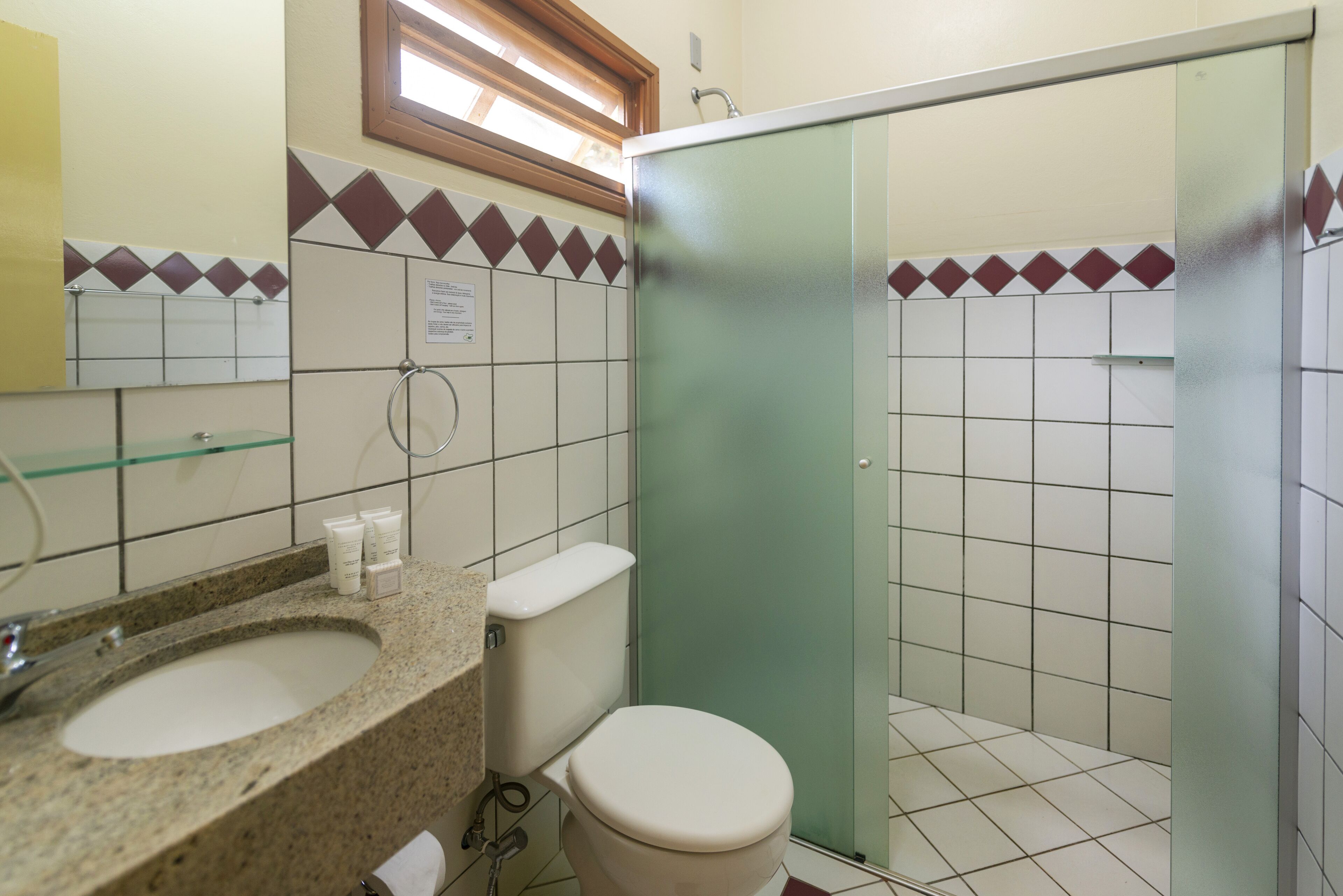 A bathroom with a sink, toilet, and shower.