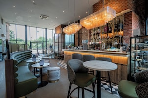 A modern bar area with seating, a counter, and a view of the outdoors.