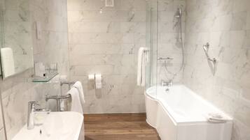 A modern bathroom with a glass shower enclosure, a freestanding bathtub, and a vanity with a sink.
