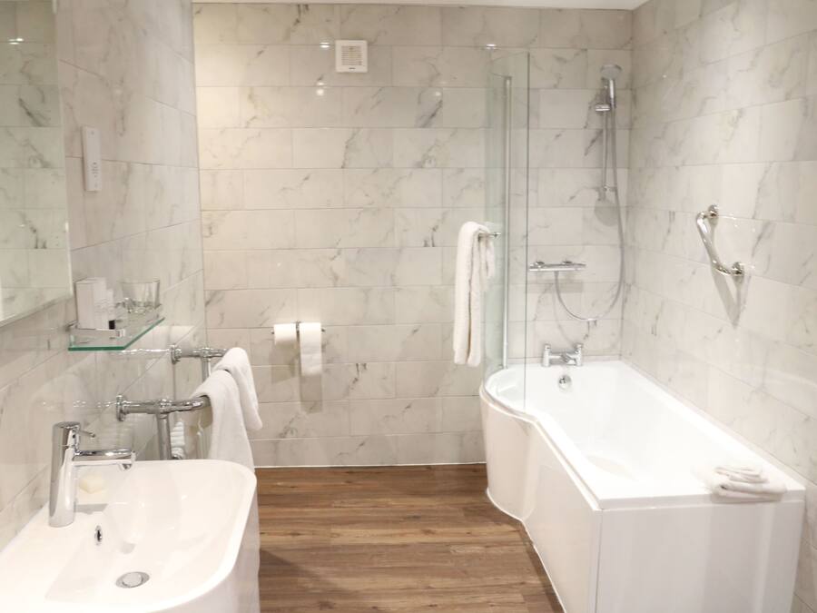 A modern bathroom with a glass shower enclosure, a freestanding bathtub, and a vanity with a sink.