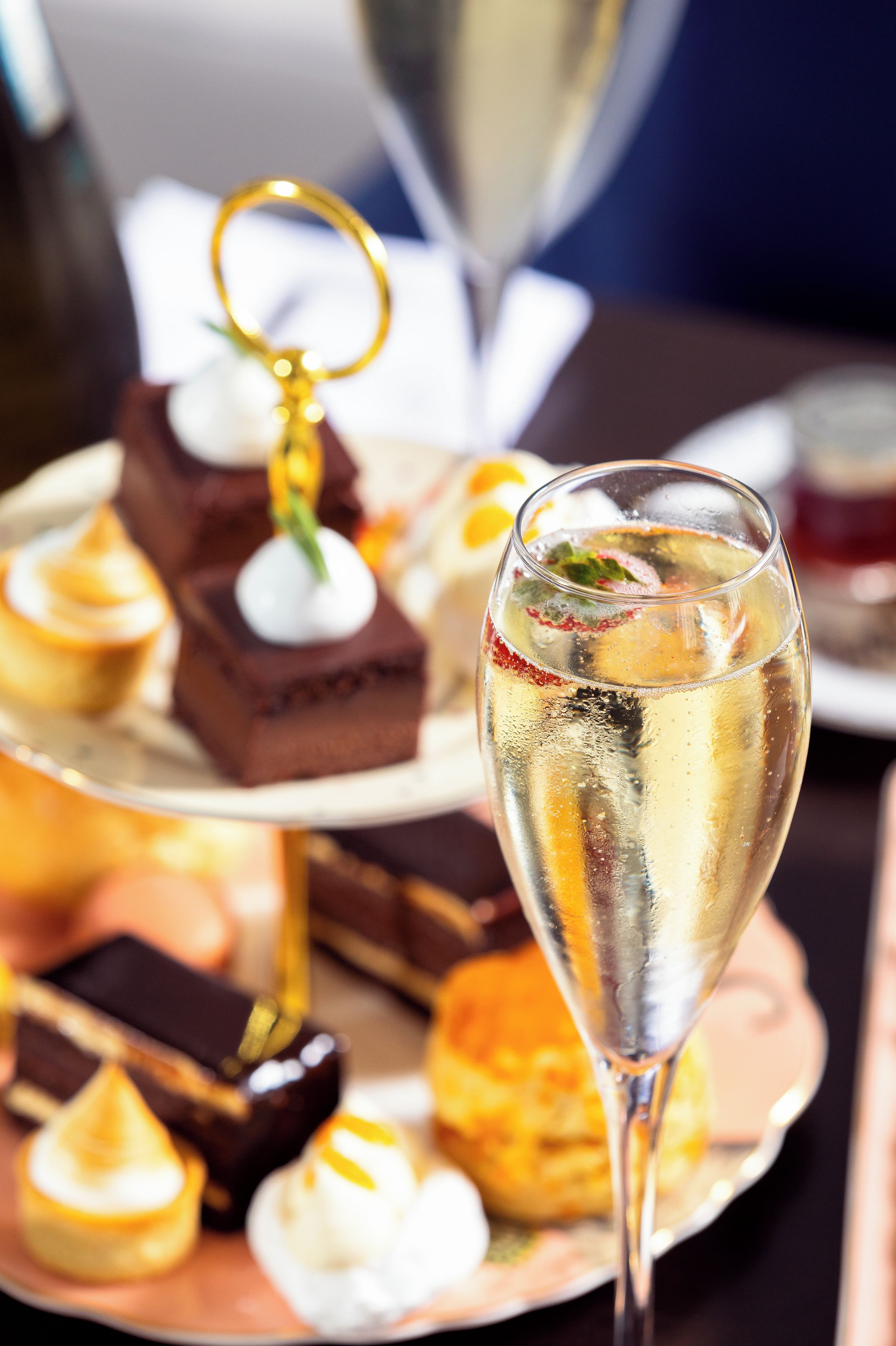 A dessert platter with various sweets and a glass of champagne.