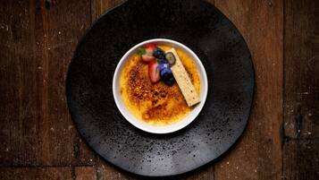 A dessert on a black plate with a wooden background.