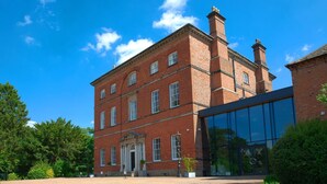 A large brick building with a central entrance and a glass extension. - Winstanley House (Leicester)