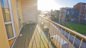 Ein Balkon mit Blick auf eine Straße und Gebäude.