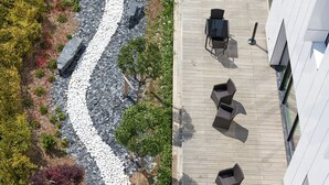 A rooftop garden with a winding path, outdoor seating, and a building with multiple windows. - Toyoko Inn Marseille Saint Charles (Marseille)