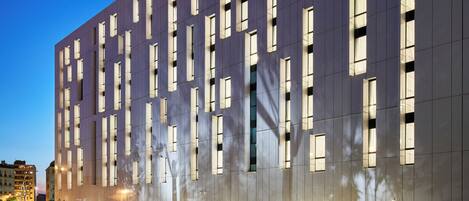 Ein modernes Gebäude mit einem Gitter aus Fenstern und einer ebenen Fassade.