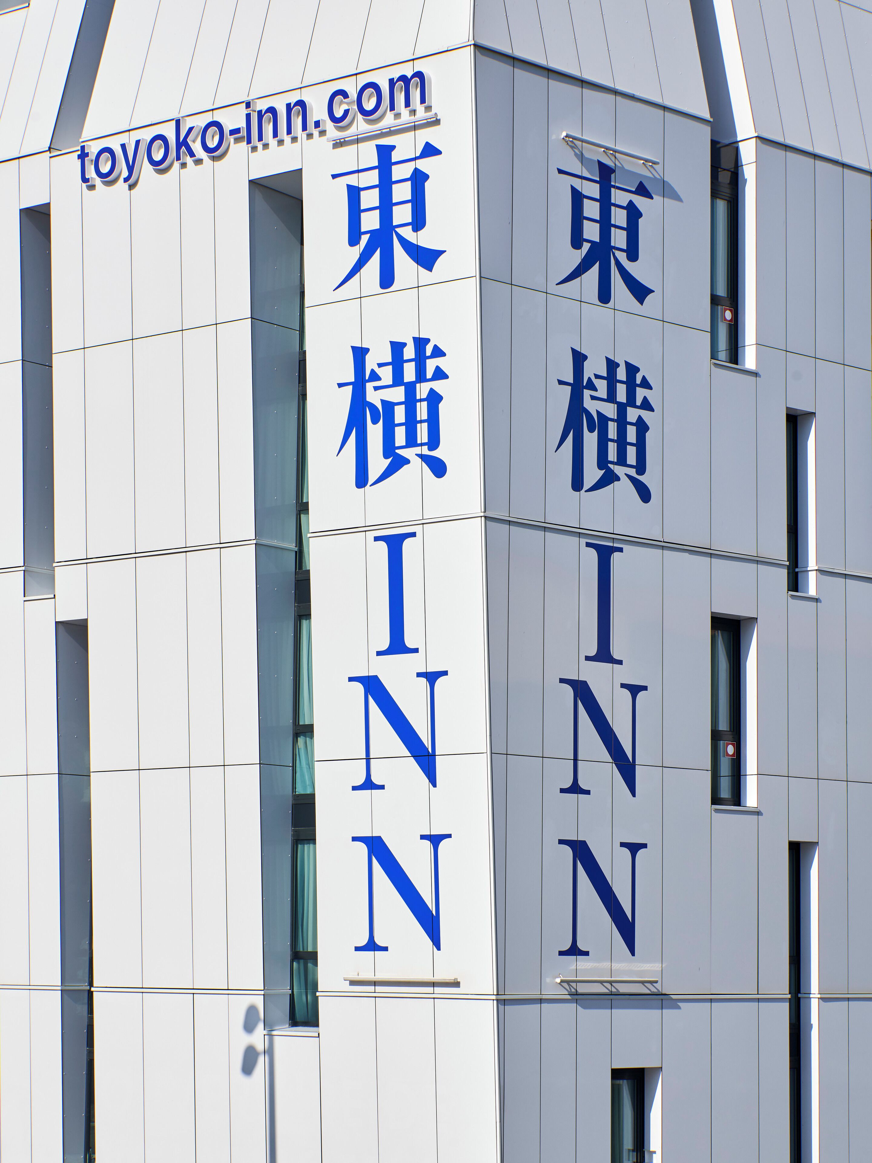 Un edificio con la segnaletica "Toyoko Inn" e caratteri giapponesi.