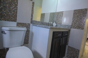 Un baño con inodoro, lavabo y armarios.