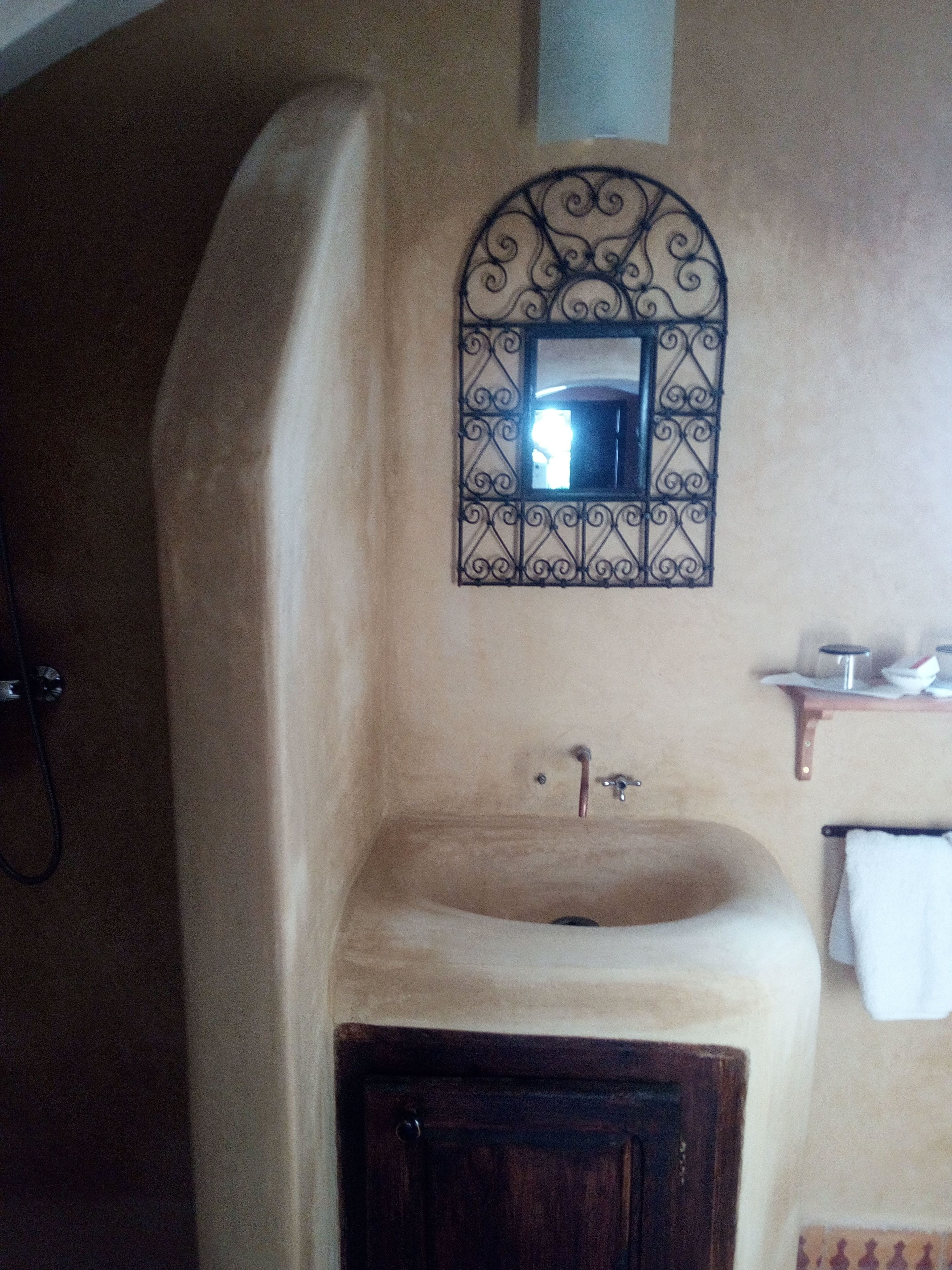 Ein Badezimmer mit Waschbecken, Spiegel und Handtuchhalter.