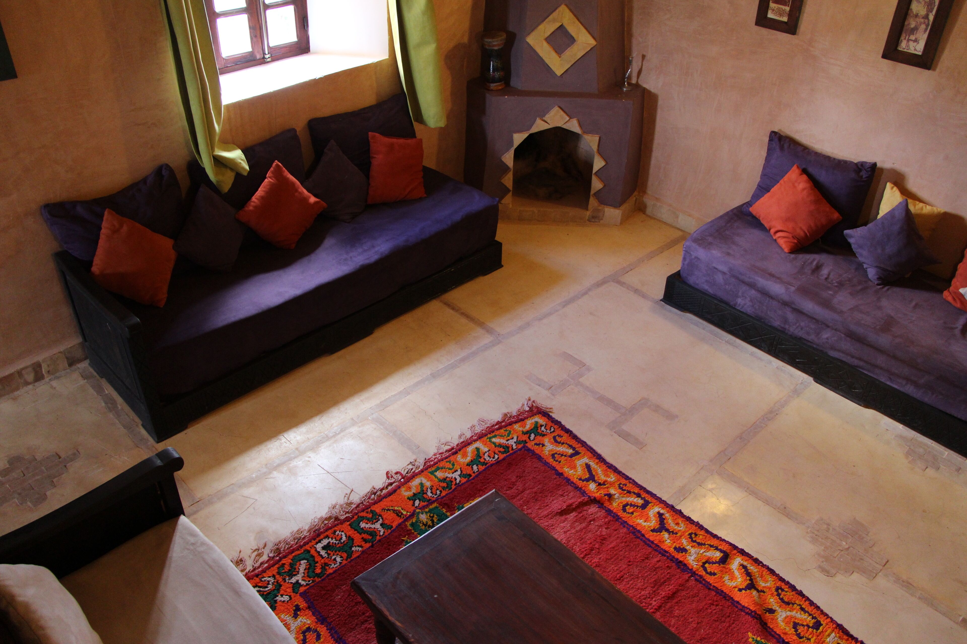 Una sala de estar con dos sofás, un tapete estampado y una chimenea.