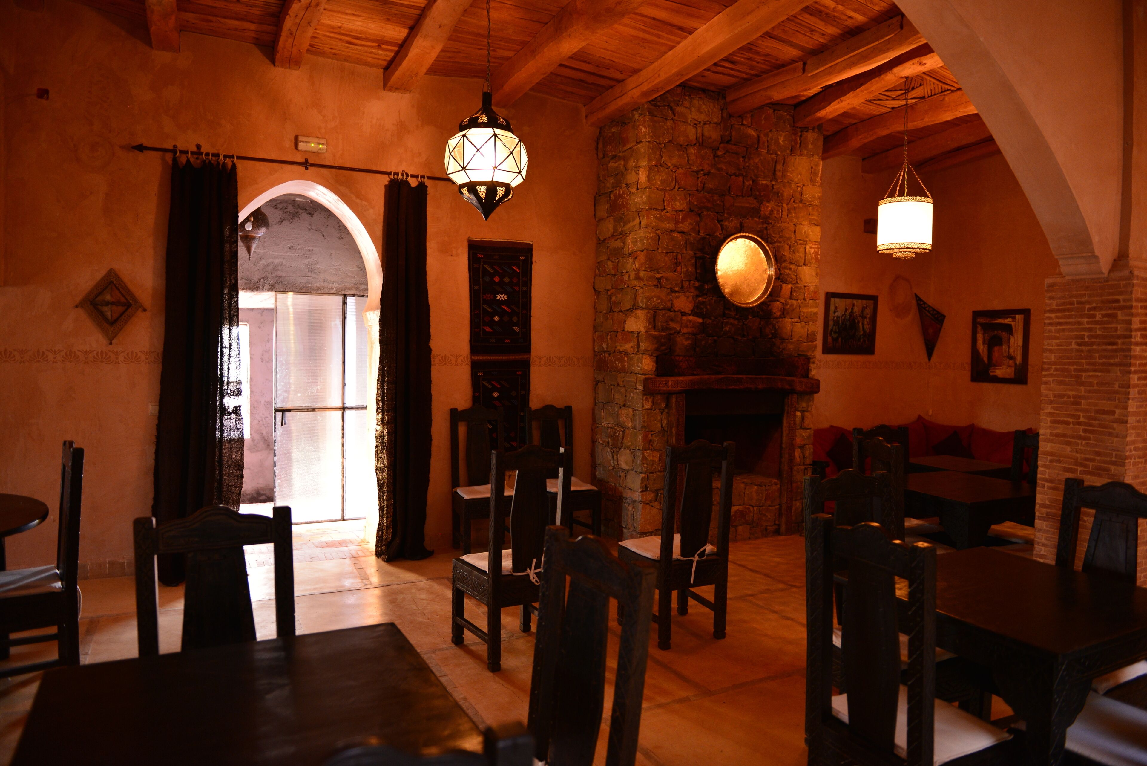 A cozy dining area with wooden furniture, a stone wall, and a fireplace.