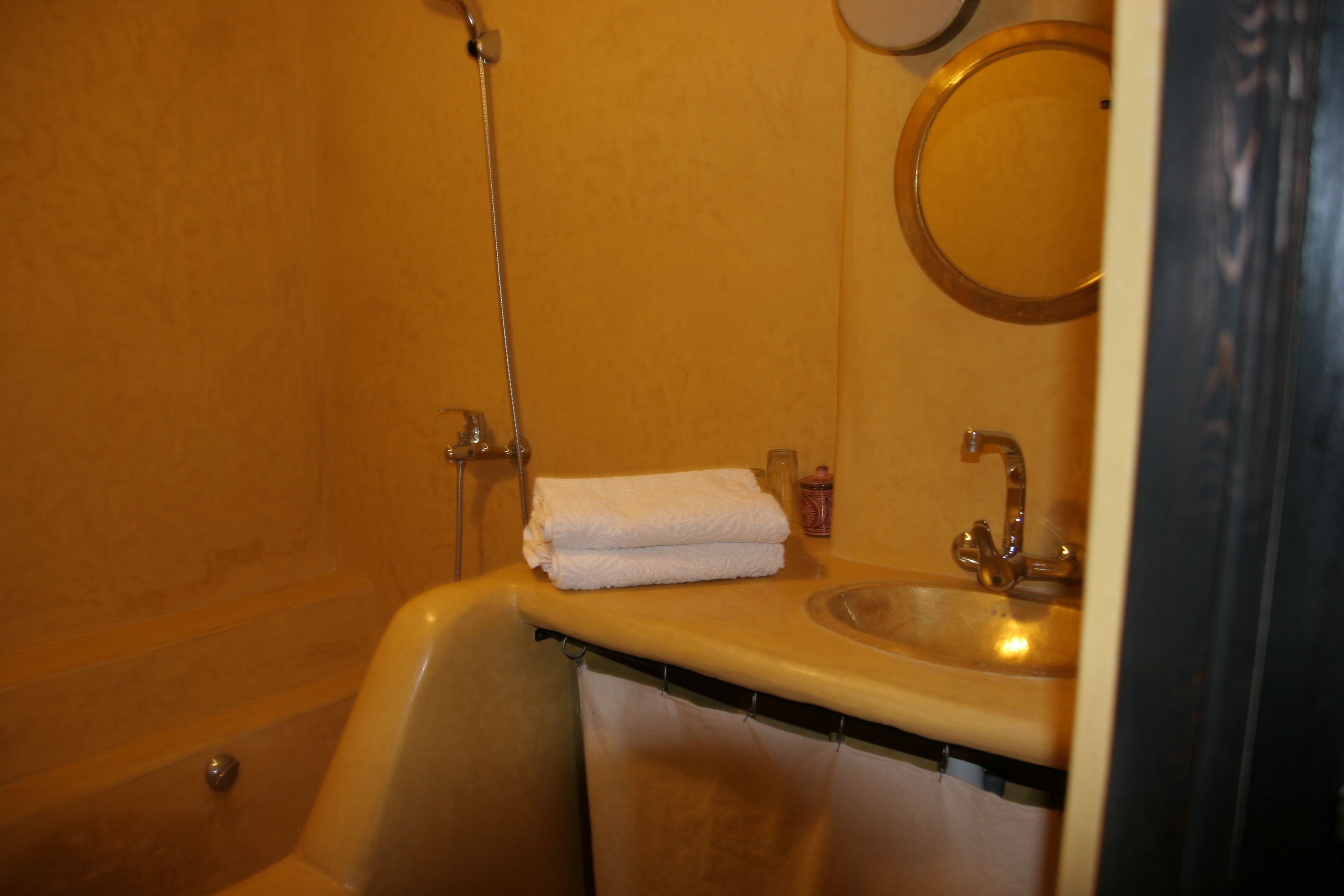 A bathroom with a bathtub, a sink, and a mirror.