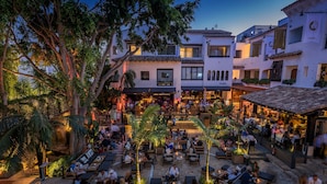 Un cortile con posti a sedere all'aperto, circondato da edifici con insegne 'Nobu' e 'NOBU'.