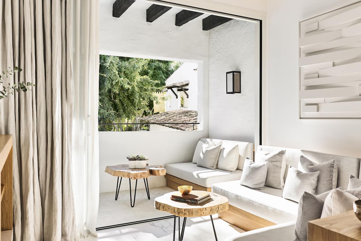 Una sala de estar moderna con un sofá blanco, una mesa de centro y vistas a zonas verdes.