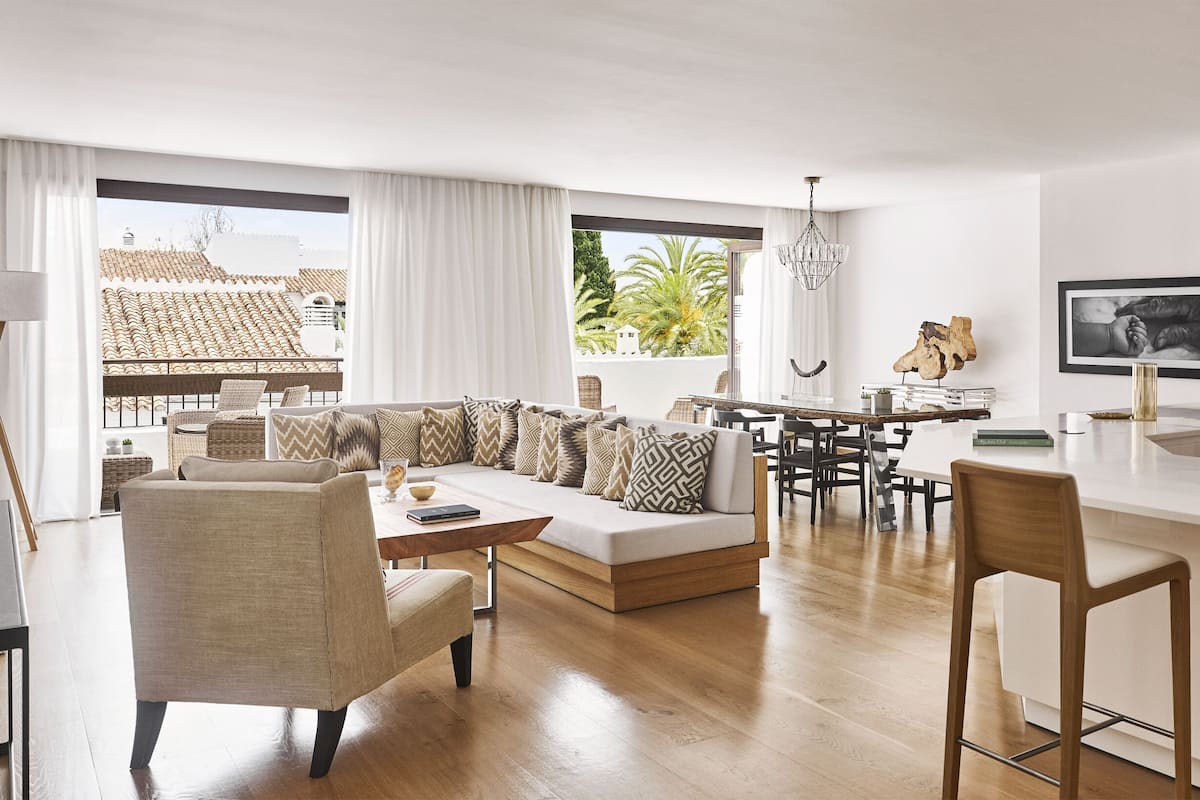 Una sala de estar moderna con un sofá, sillas y un comedor.