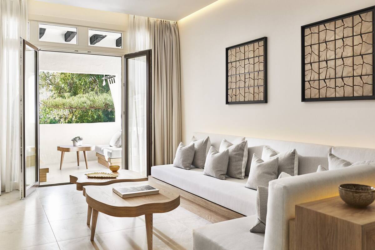 Una sala moderna con sofá, mesa de centro y vistas al exterior.