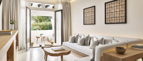 Una sala moderna con sofá, mesa de centro y vistas al exterior.