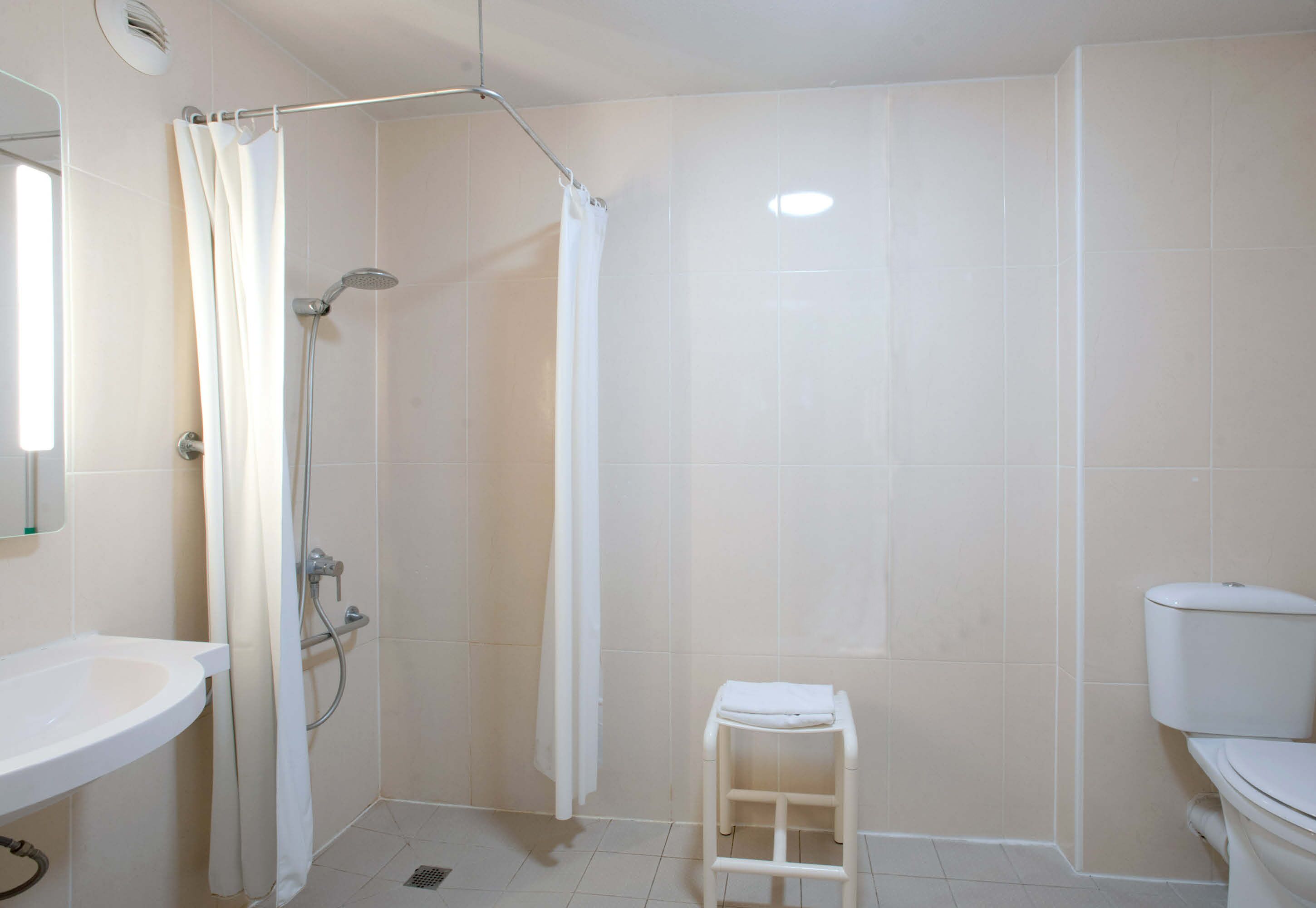 A bathroom with a shower, toilet, and sink.