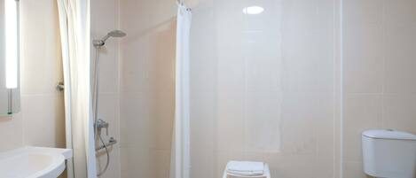 A bathroom with a shower, toilet, and sink.