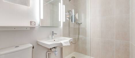 A modern bathroom with a toilet, sink, and shower.