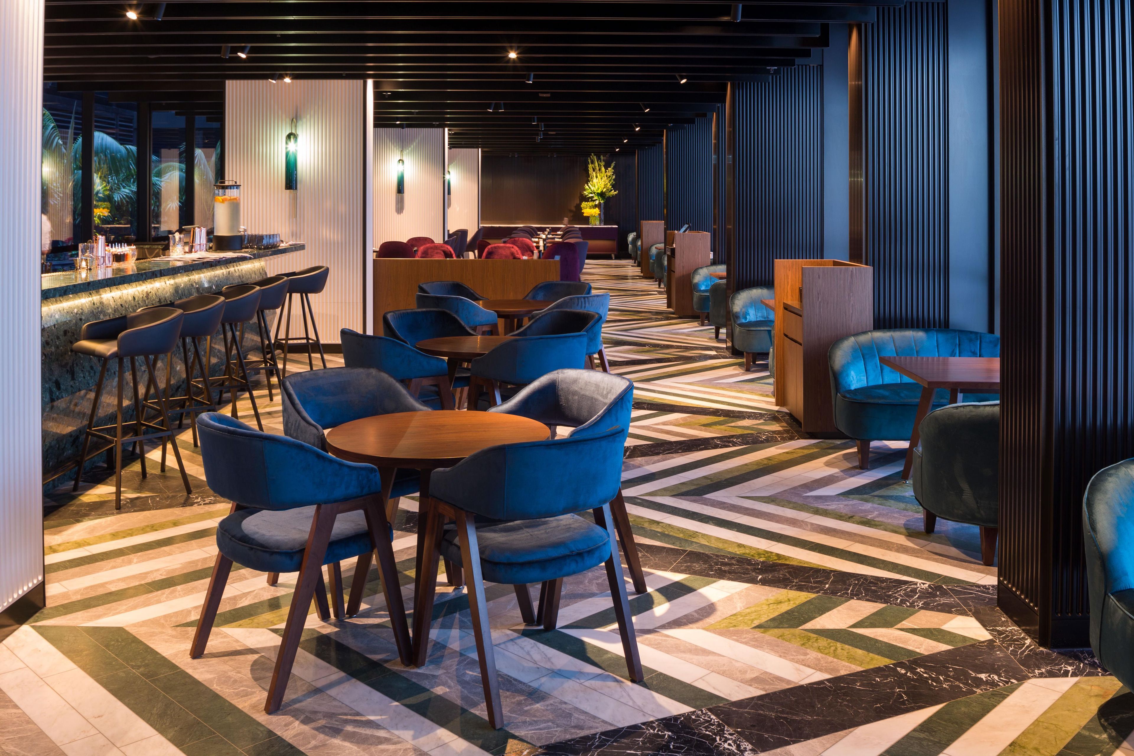 Een moderne lounge met een bar, tafels en stoelen.
