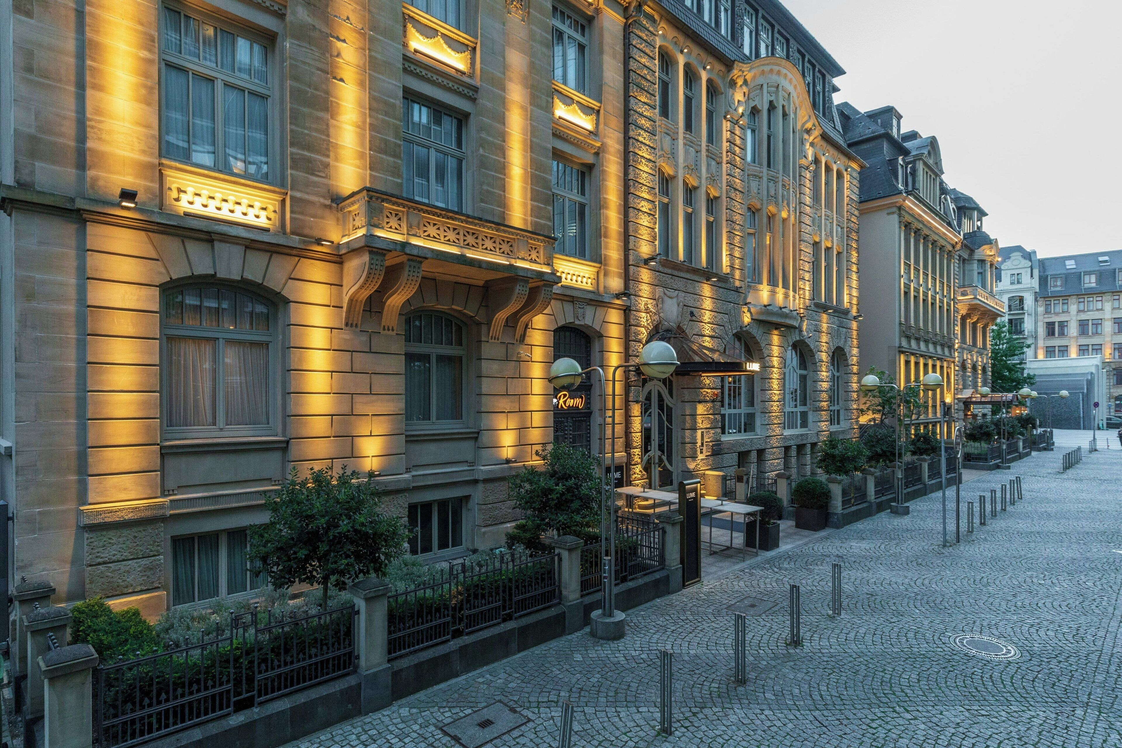 Ein historisches Gebäude mit aufwendiger Architektur, eine Kopfsteinpflasterstraße und ein gut beleuchteter Eingang.