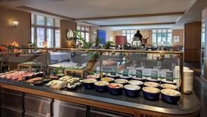 A buffet area with various food options and a seating area in the background. - LUME Boutique Hotel, Autograph Collection (Frankfurt)