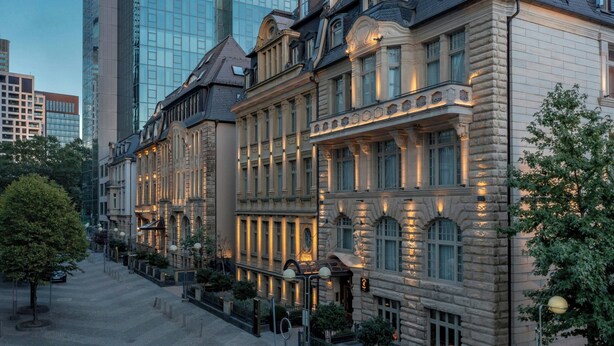 A historic building with classical architecture, featuring multiple stories, large windows, and a well-lit facade. - LUME Boutique Hotel, Autograph Collection (Frankfurt)