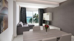 A modern living room with a dining area, a sofa, a coffee table, and a view of the ocean. - Boca Beach Residence (Boca Chica)