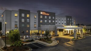 A modern hotel with a prominent Hilton Garden Inn sign, a covered entrance, and a landscaped driveway. - Hilton Garden Inn Jackson (Jackson)