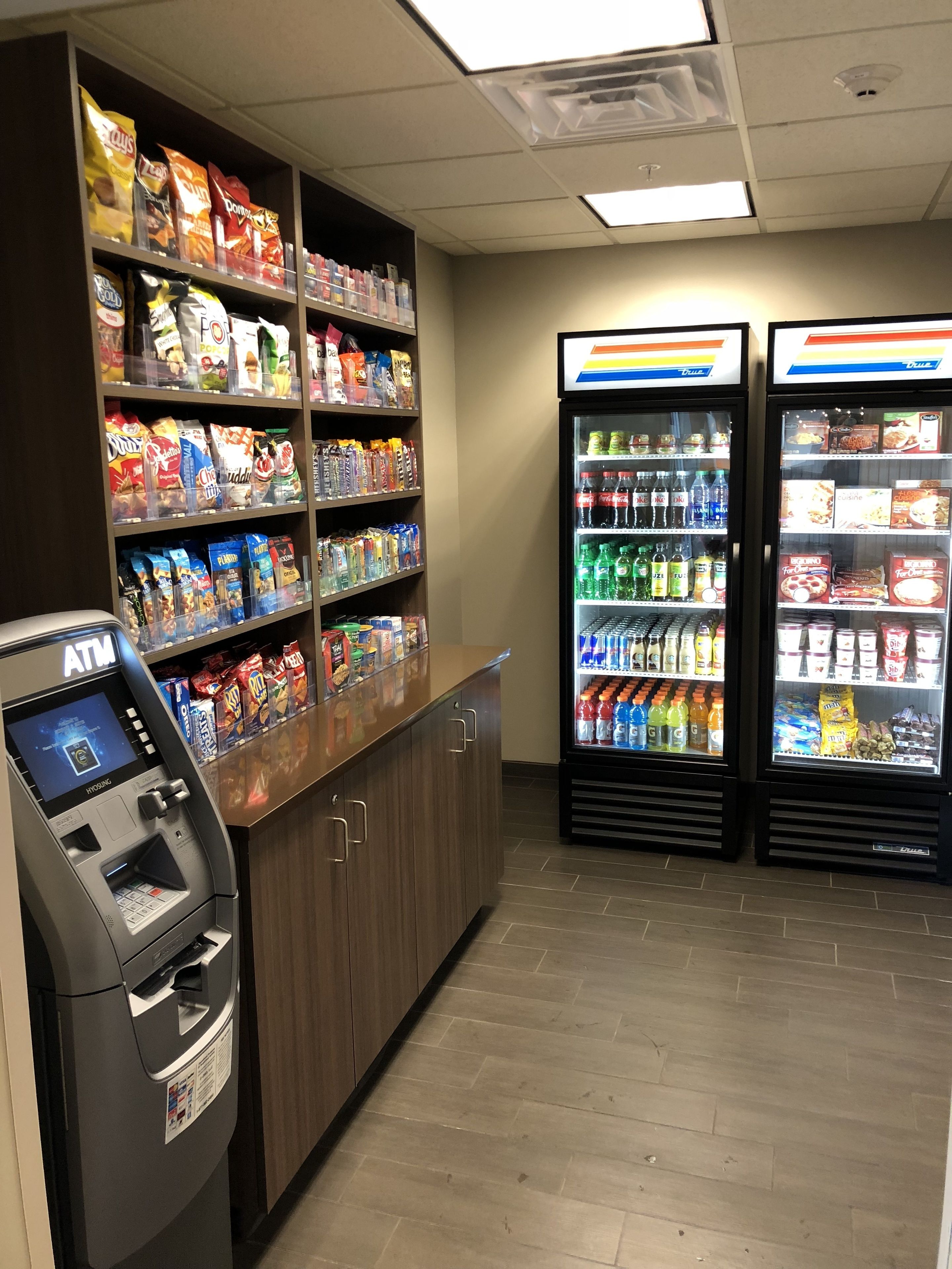 A self-service kiosk with snacks and beverages, including chips, sodas, and bottled water.